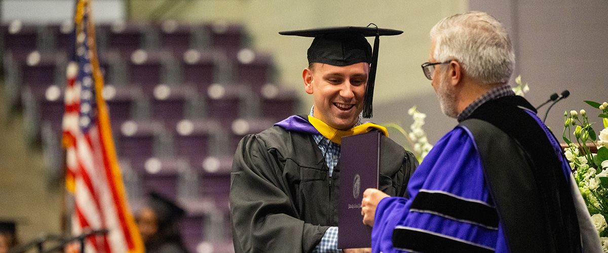 Student at graduation receiving his diploma
